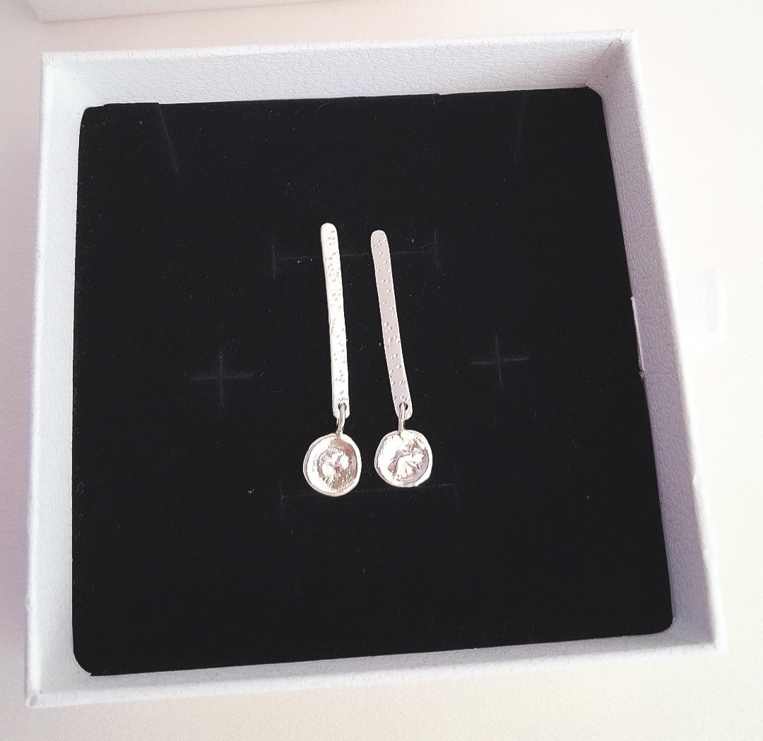 Mujer llevando pendientes Ripple minimalistas