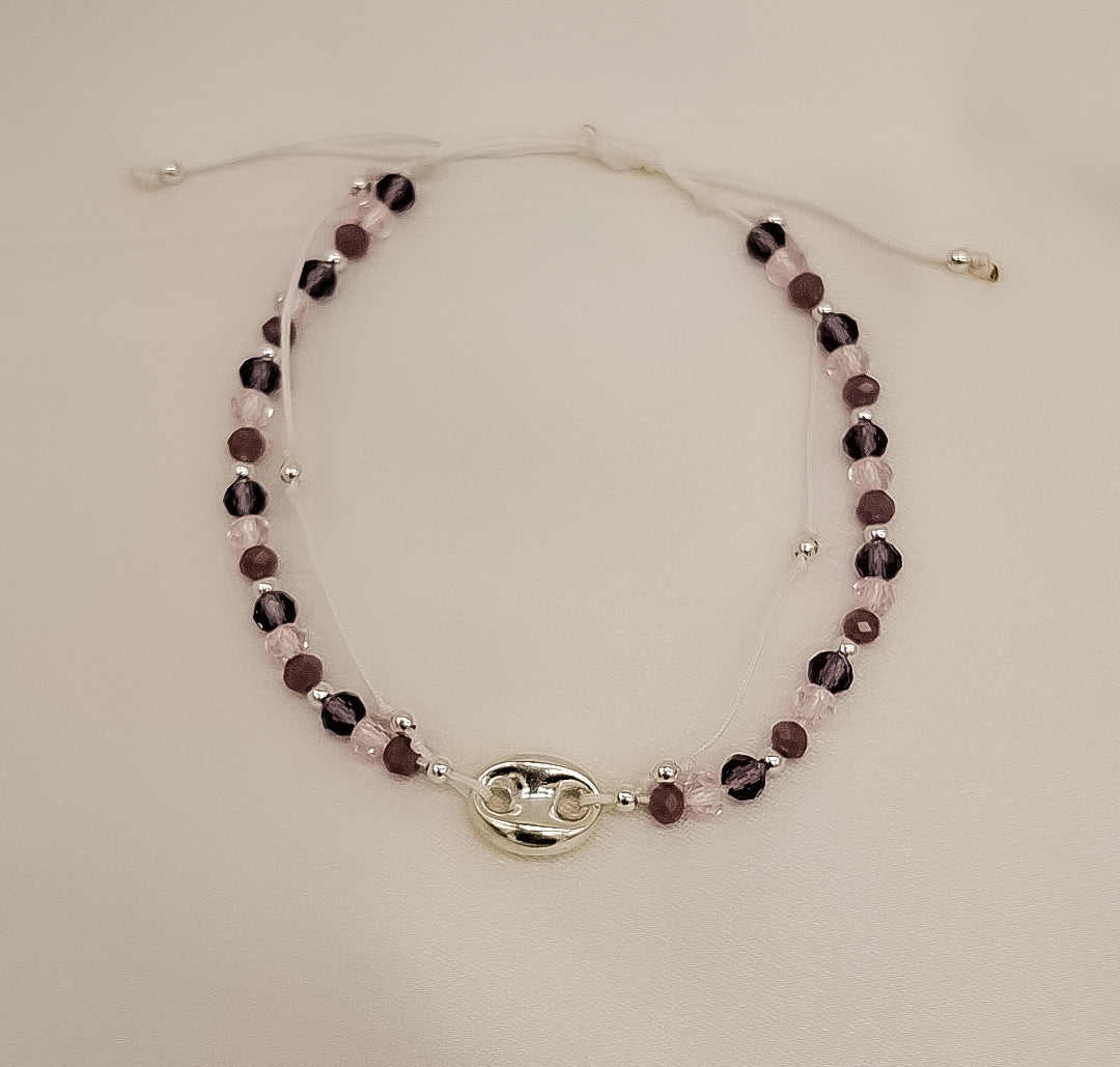 Pulsera ajustable hecha a mano con cristales facetados en tonos amatista y charm central en plata de ley, diseño exclusivo de Pétalos de Plata.