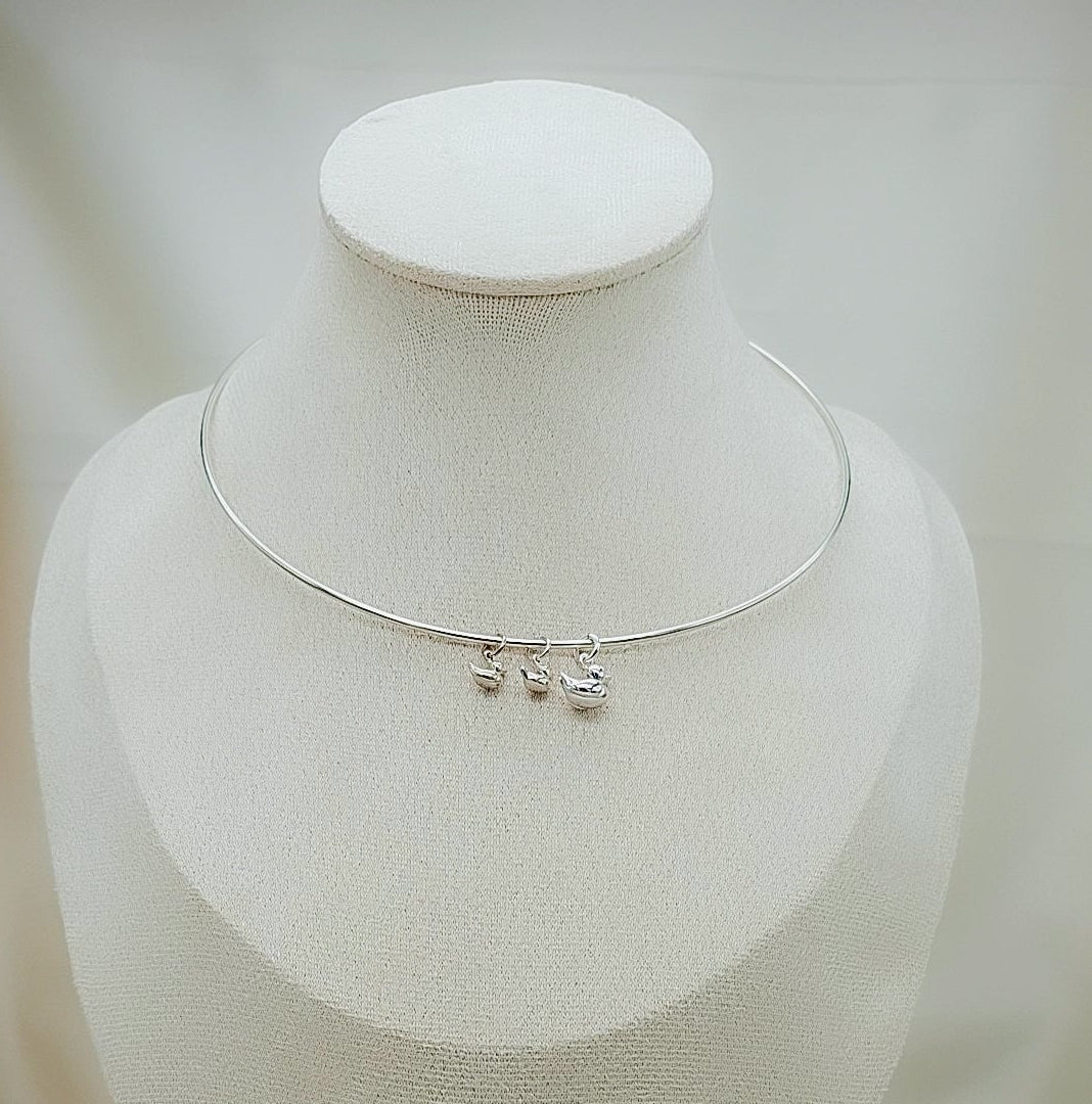 
Collar de plata con diseño de mamá patita y sus patitos, joya artesanal tierna y significativa de Pétalos de Plata.