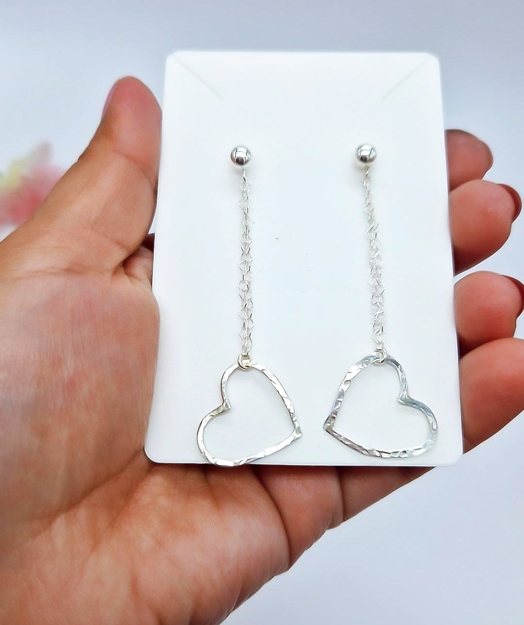Petalos de plata pendientes de cadenas y corazones.