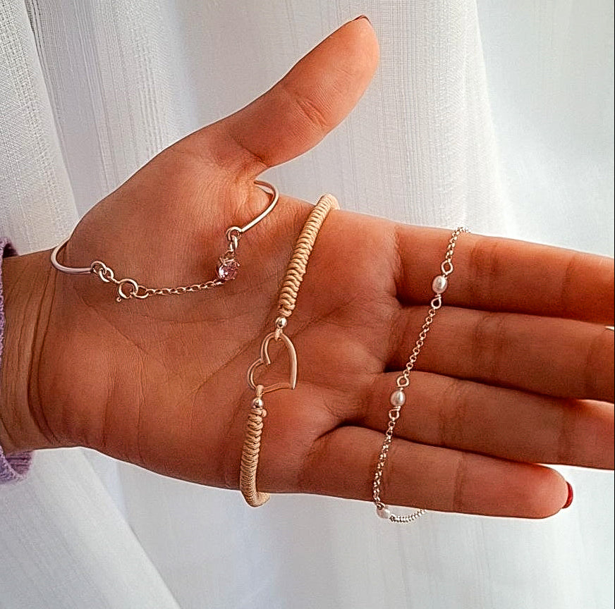 Stack de pulseras de plata y perlas sobre mano