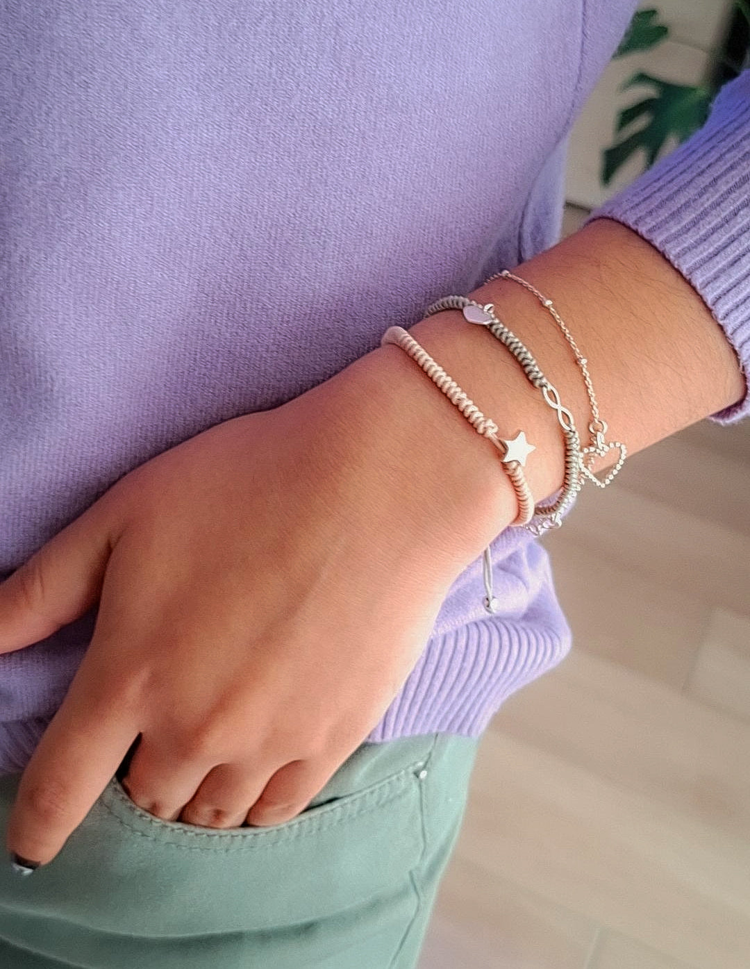 Mujer llevando stack de pulseras de plata minimalistas
